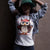 Cute cartoon owl cheerleader holding a pom-pom and clipboard, wearing a red cap with the quote “Behind Every Great Swing Is a Loud Mom” – featured on garment-dyed heavyweight cotton tee