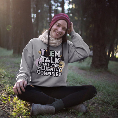 Person wearing a sweatshirt with text sitting in a forest