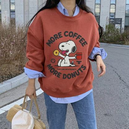 Person wearing a red sweatshirt with a cartoon character and text, standing outdoors.