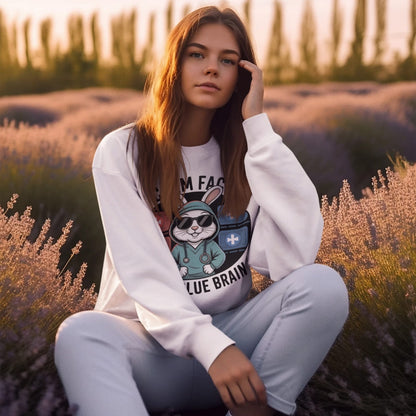 Woman sitting in a lavender field wearing a white sweatshirt with a graphic design.