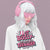 Person wearing pink heart-shaped sunglasses, pink earmuffs, and a white sweatshirt with text on a purple background
