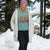 Person wearing a teal sweatshirt with motivational text in a snowy outdoor setting