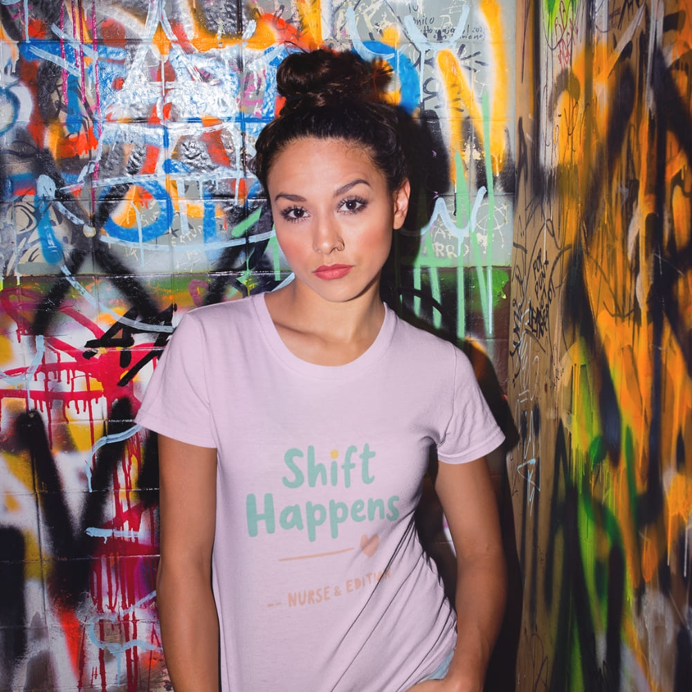 “Shift Happens – Nurse Edition” pastel text design printed on a thick garment-dyed cotton t-shirt, perfect for nurses and healthcare professionals with a sense of humor.