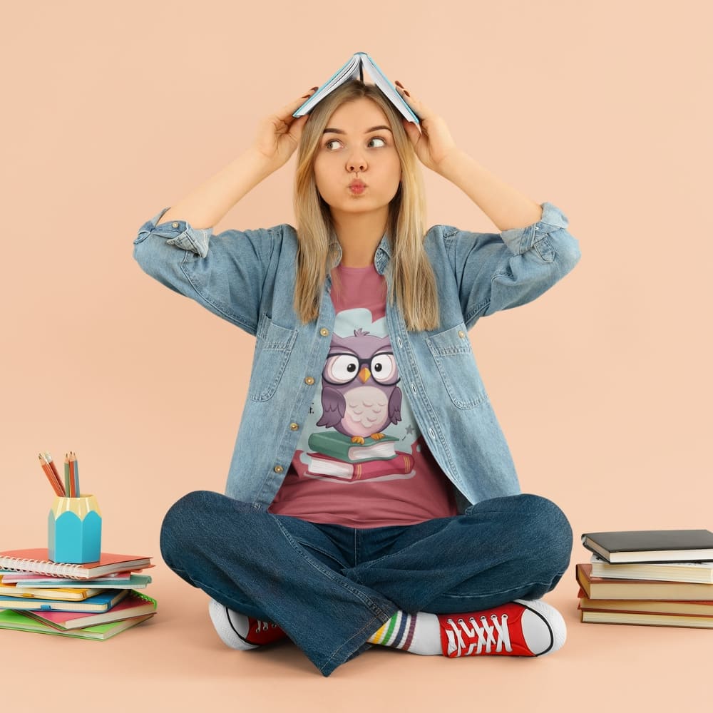 Cute purple owl with glasses sitting on stacked books, with quote "Teach. Inspire. Repeat." – printed on a teacher t-shirt