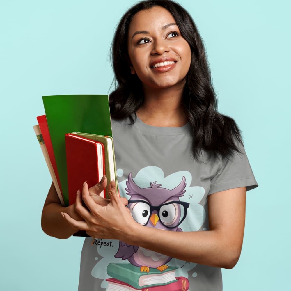 Cute purple owl with glasses sitting on stacked books, with quote "Teach. Inspire. Repeat." – printed on a teacher t-shirt