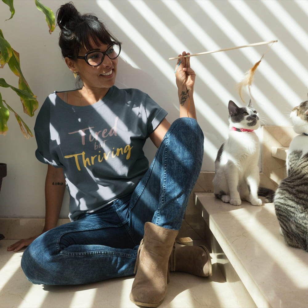 Garment-dyed relaxed fit t-shirt with motivational quote “Tired But Thriving” in modern handwritten script