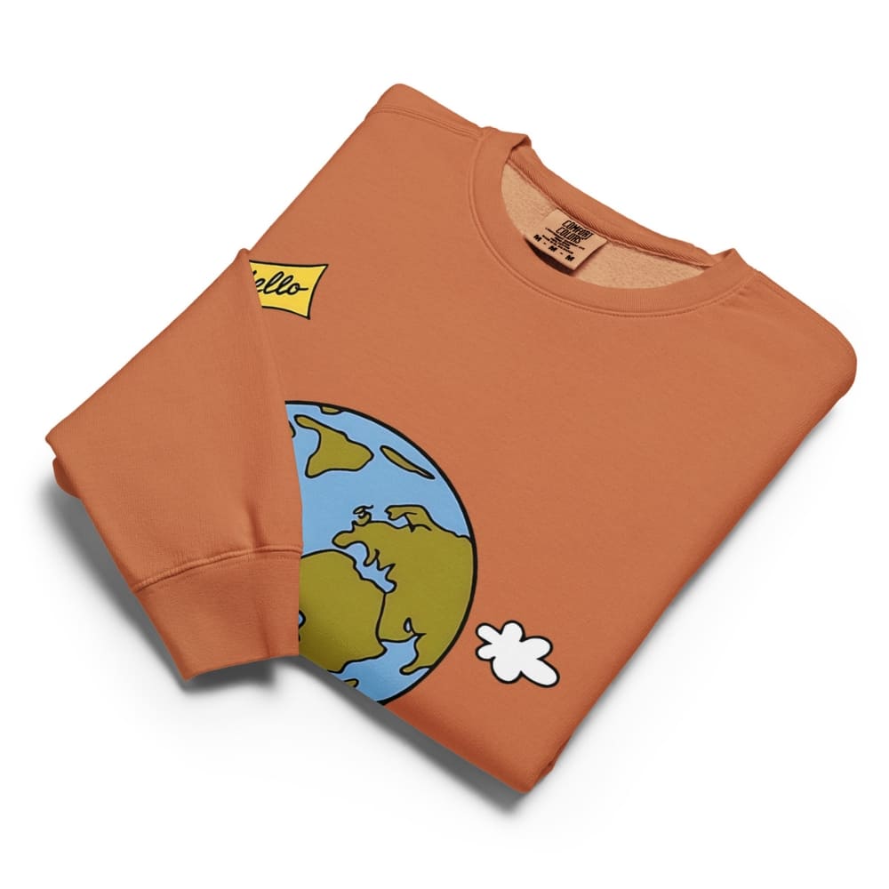 Folded orange sweatshirt with cartoon design on a white background