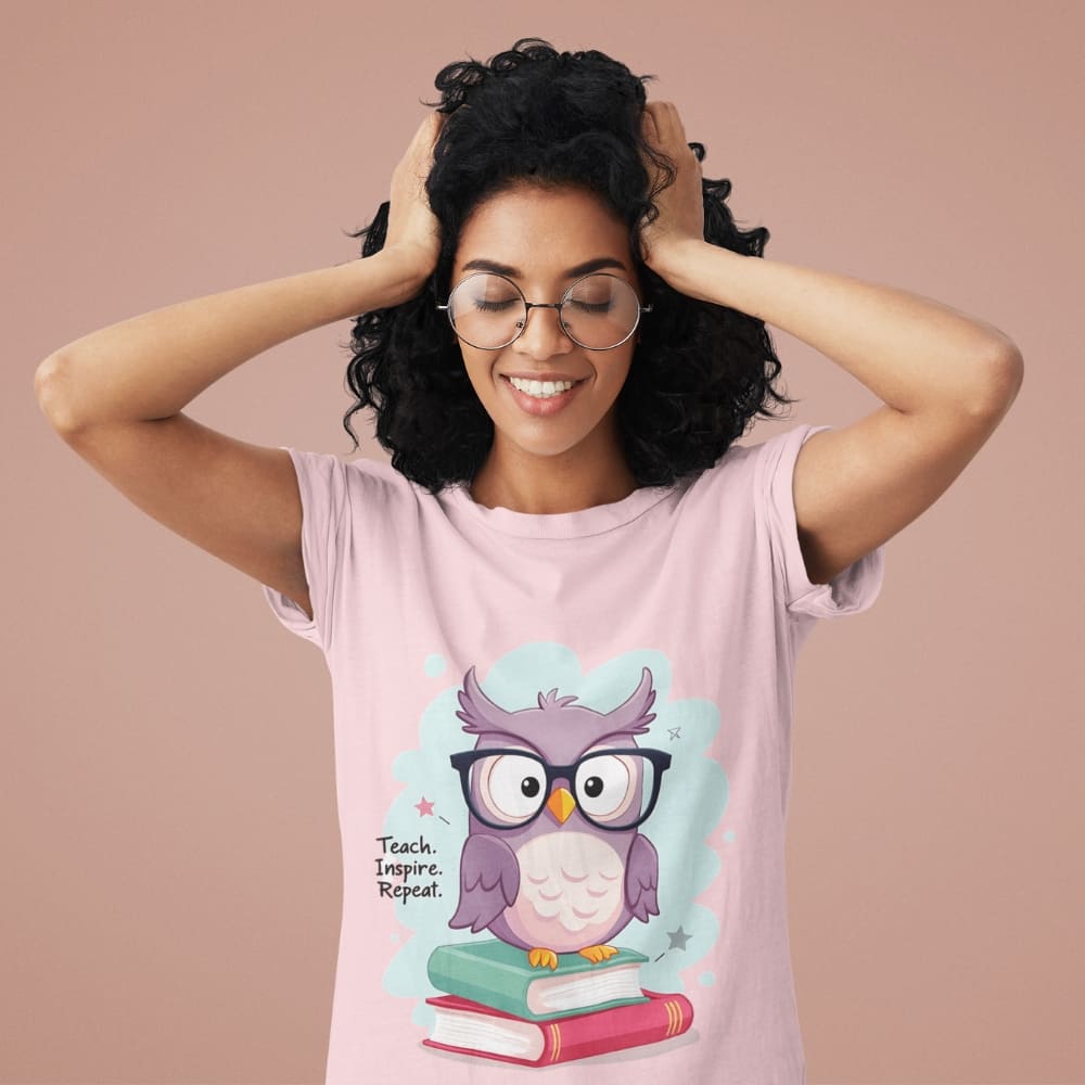 Cute purple owl with glasses sitting on stacked books, with quote "Teach. Inspire. Repeat." – printed on a teacher t-shirt