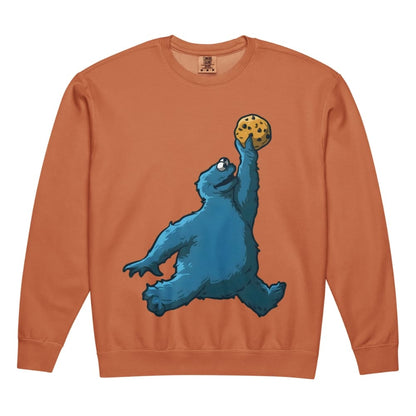 Sweatshirt with a blue creature holding a cookie on an orange background