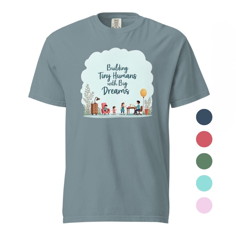 Illustrated t-shirt design with the quote "Building Tiny Humans with Big Dreams" surrounded by a family parenting scene