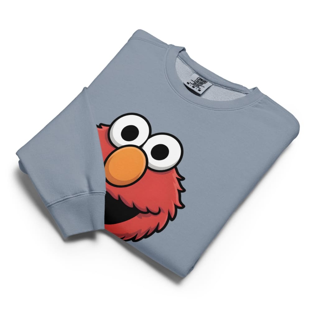 Folded light blue sweatshirt with a cartoon character design on a white background