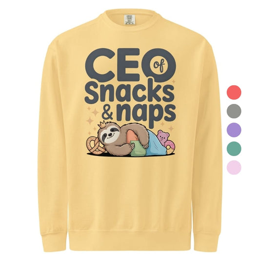 "CEO of Snacks & Naps" printed sweatshirt featuring a sloth in a crown surrounded by pretzels and plushies on vintage-washed cotton fleece