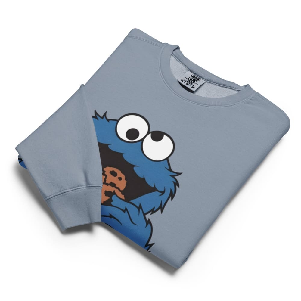 Folded blue sweatshirt with a cartoon character design on a white background