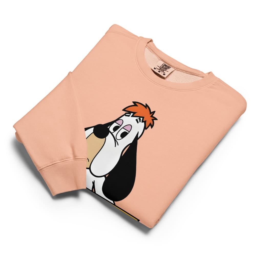 Folded peach-colored sweatshirt with cartoon character design on a white background