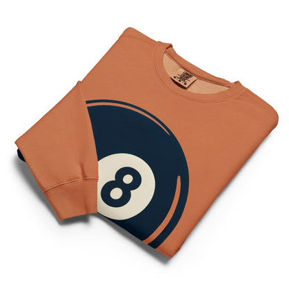 Folded orange sweatshirt with an 8-ball design on a white background