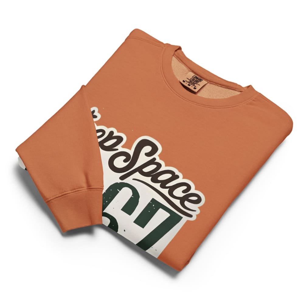 Folded orange sweatshirt with 'Keep Space' graphic on a white background