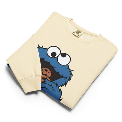 Beige sweatshirt with a blue character holding a cookie on a white background