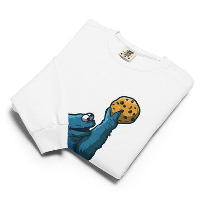 White sweatshirt with a blue creature holding a cookie design on a white background