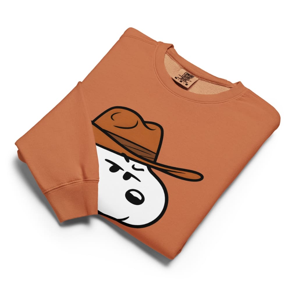 Folded orange sweatshirt with cartoon character wearing a hat on a white background