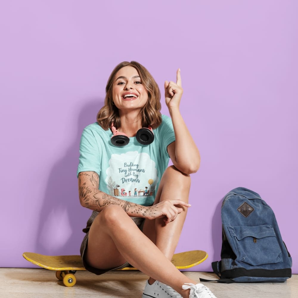 Illustrated t-shirt design with the quote "Building Tiny Humans with Big Dreams" surrounded by a family parenting scene