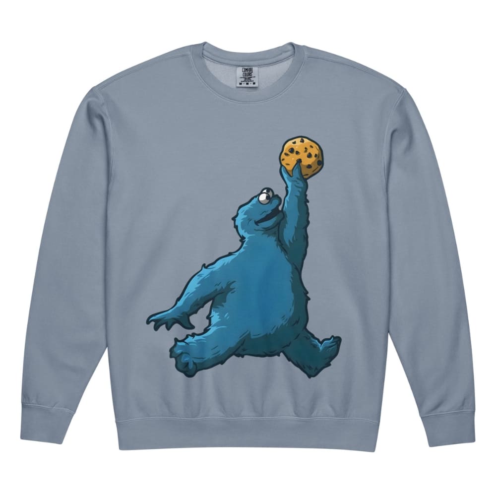 Blue sweatshirt with a blue creature holding a cookie design on a white background