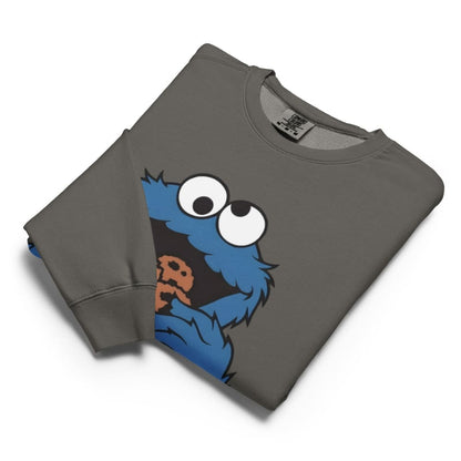 Folded gray sweatshirt with a blue character holding a cookie on a white background
