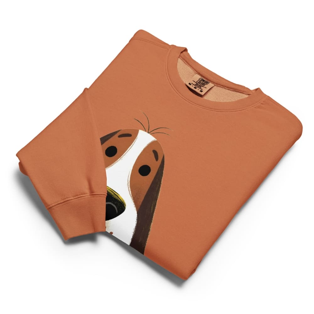 Folded orange sweatshirt with a dog face design on a white background